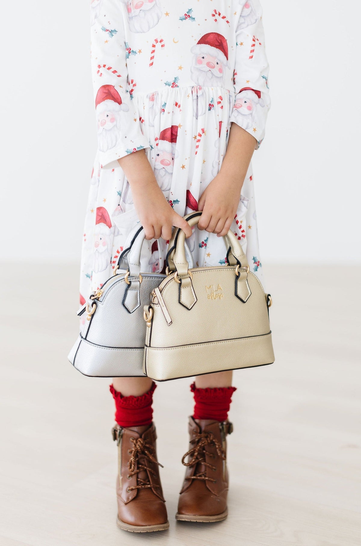 a child holding two purses