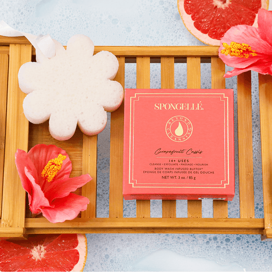 a wooden tray with flowers and sponges on it