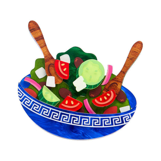 a bowl of salad with wooden spoons