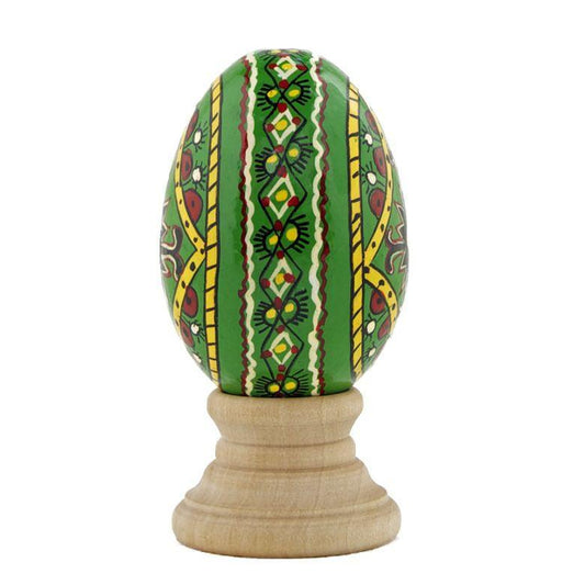a green egg with yellow and red patterns on a wooden stand