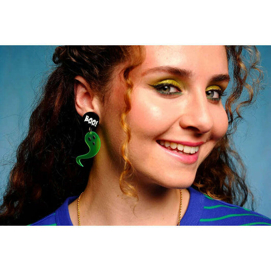 a woman with curly hair and a green earring