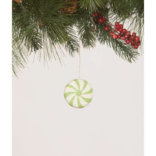 a green and white candy ornament from a pine tree