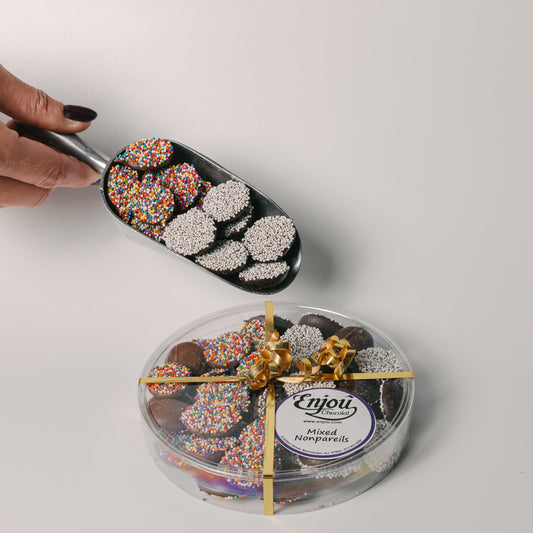 a person holding a scoop of chocolates