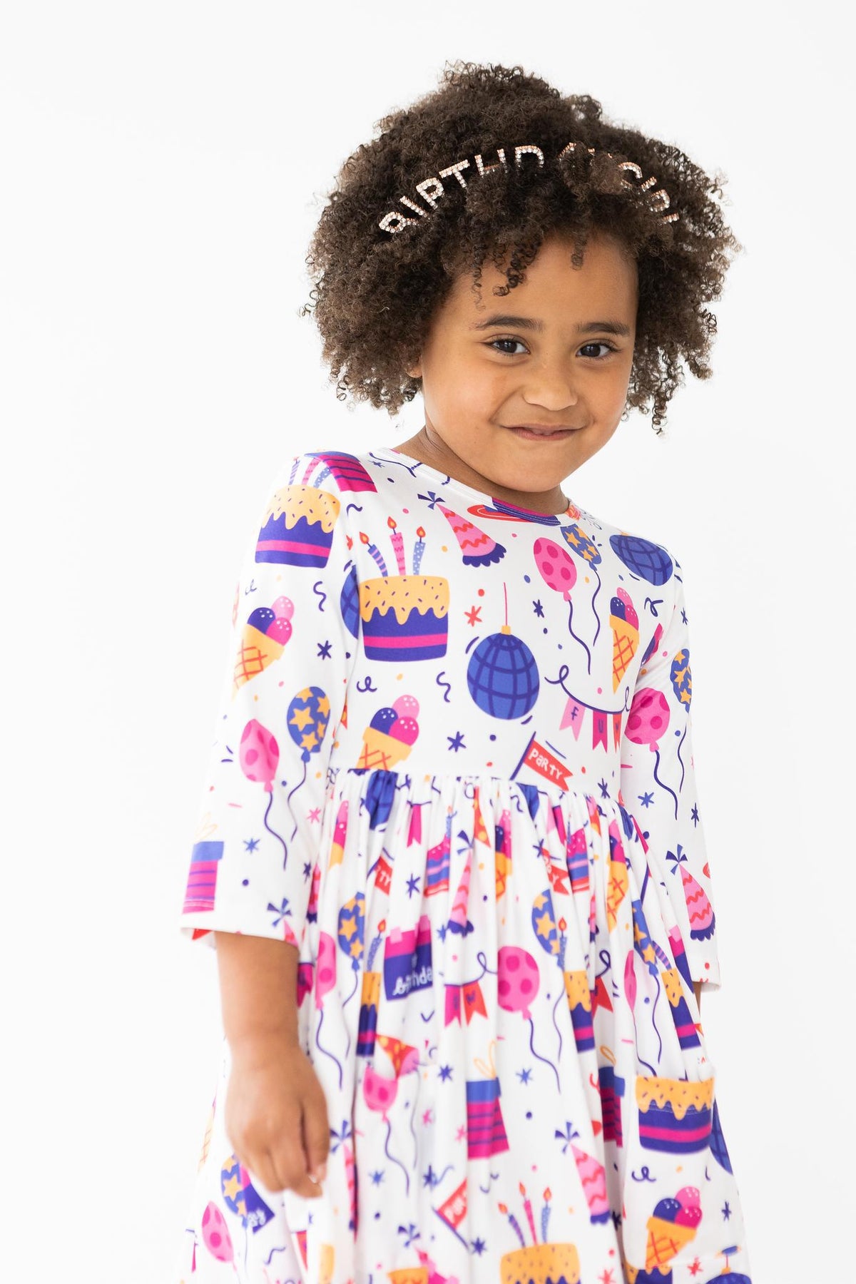 a girl with curly hair wearing a dress