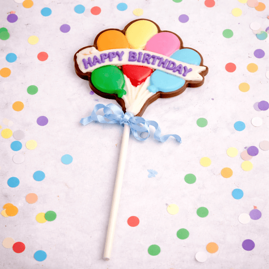 a cookie with balloons on a stick