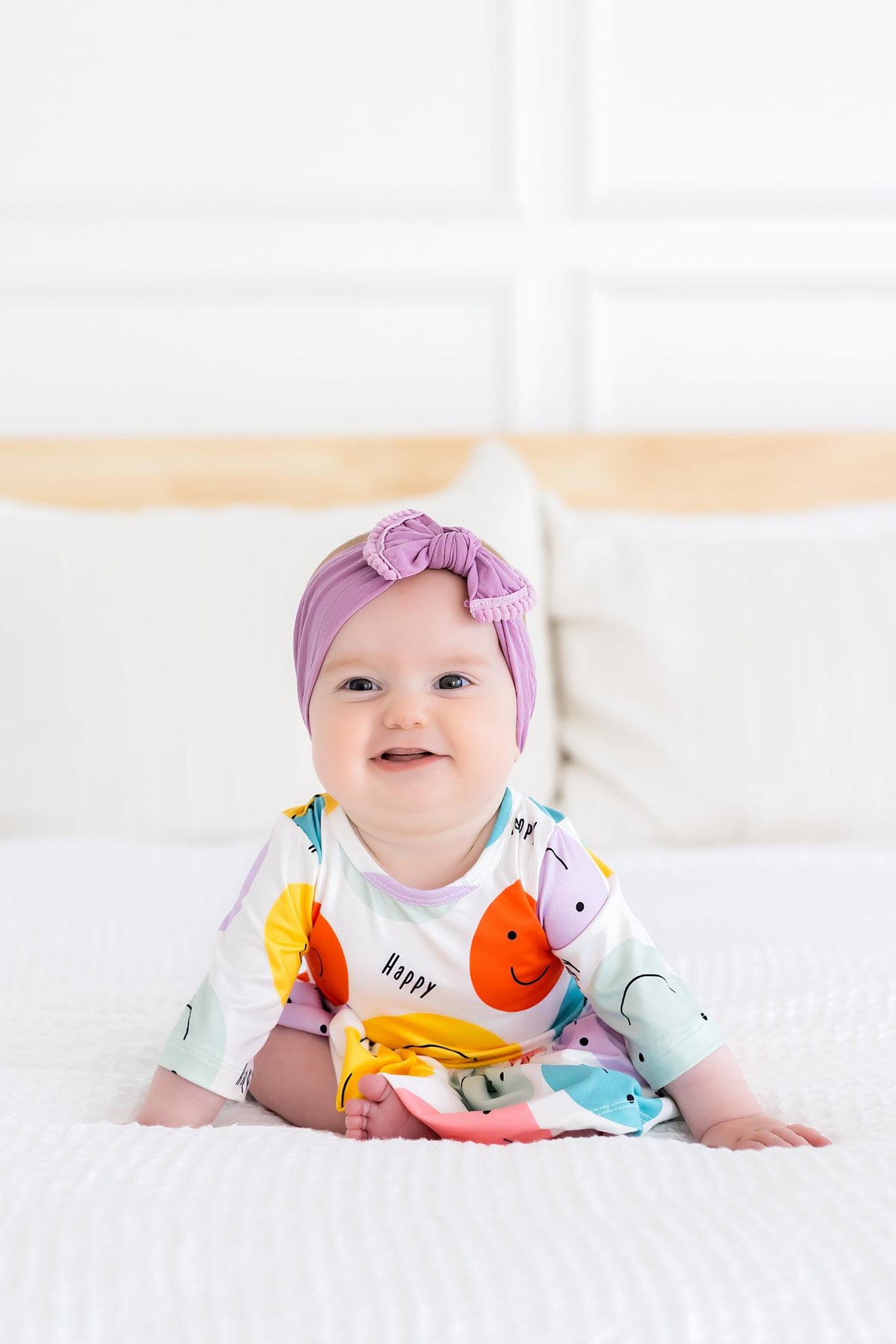 a baby sitting on a bed