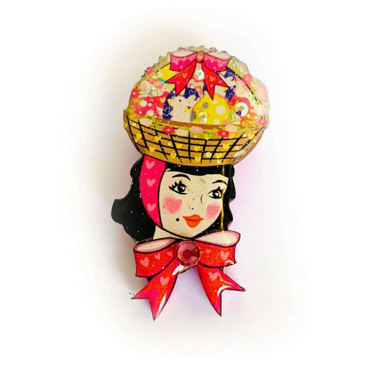 a pin with a woman's head and a basket on her head