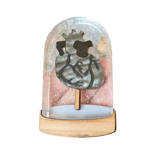 a metal figure on a stick in a glass dome