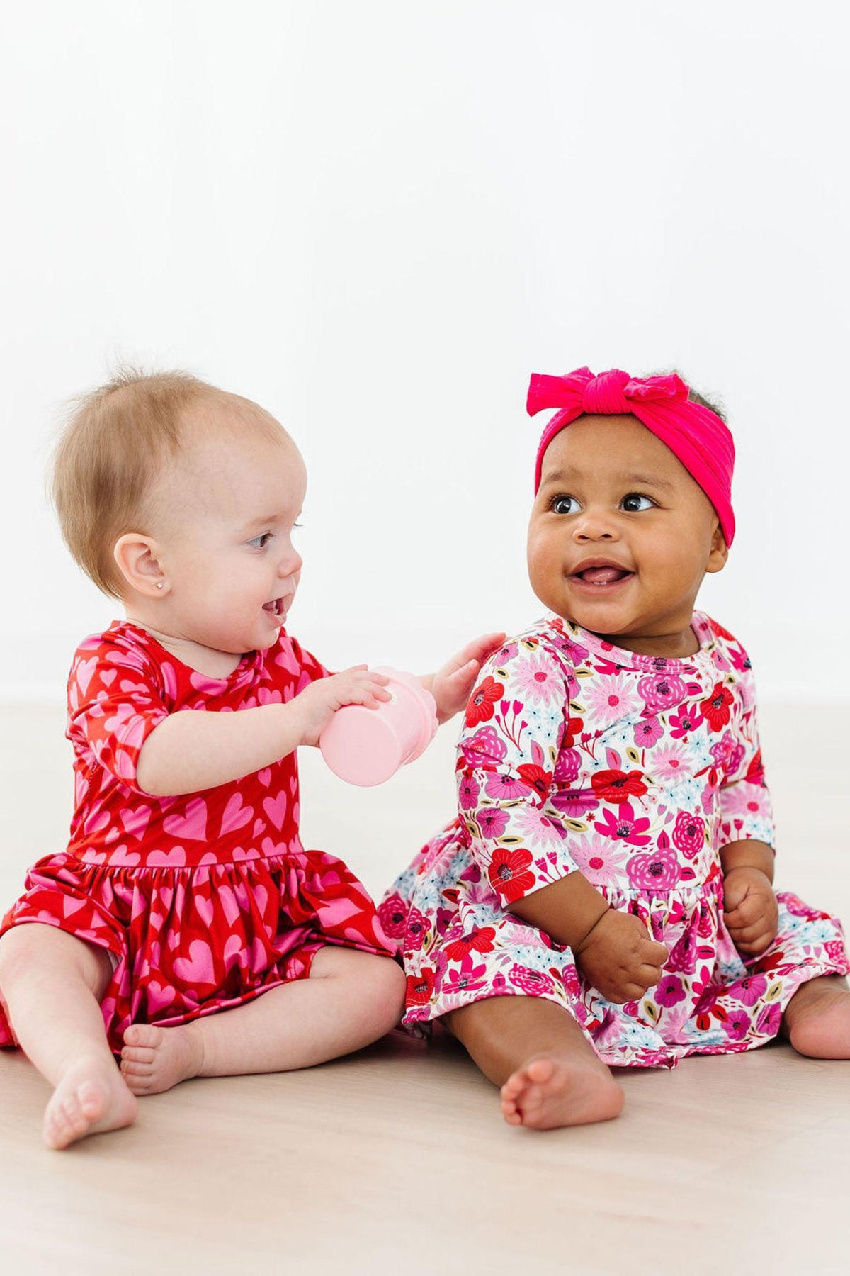 two babies sitting on the floor