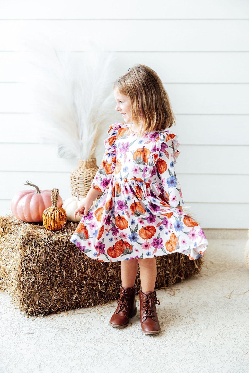 a girl standing on hay bales