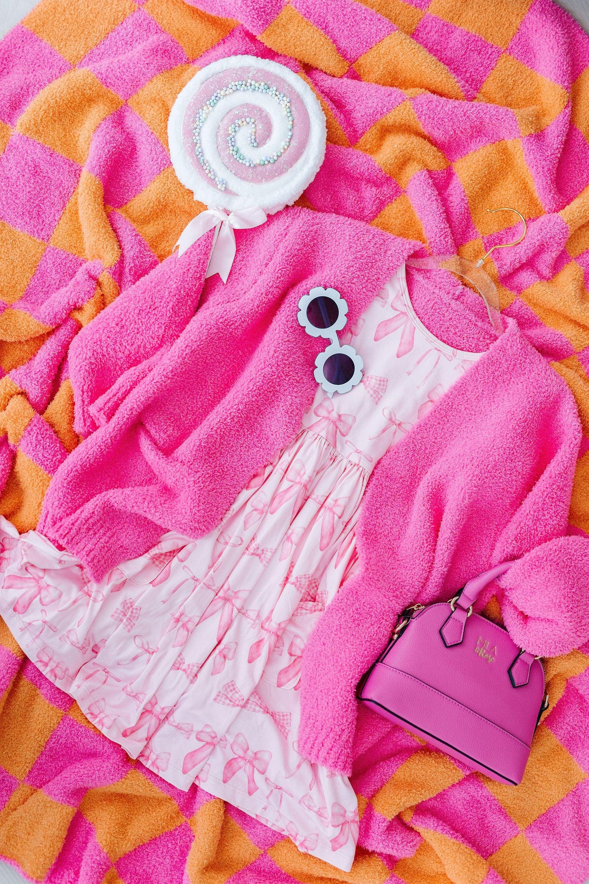 a pink and white dress and sunglasses on a blanket