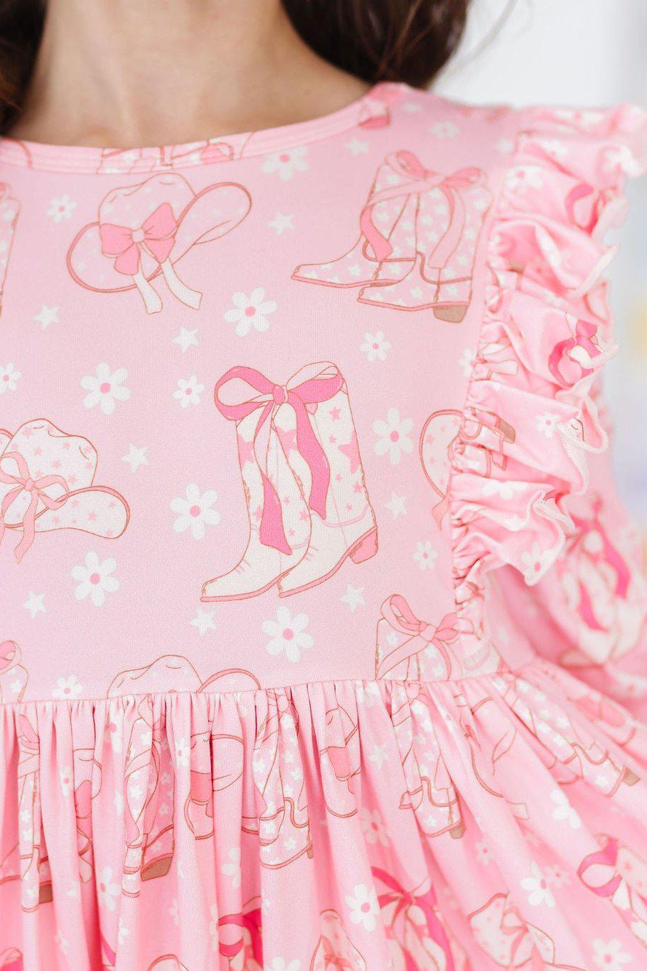 a pink dress with cowboy boots and bows
