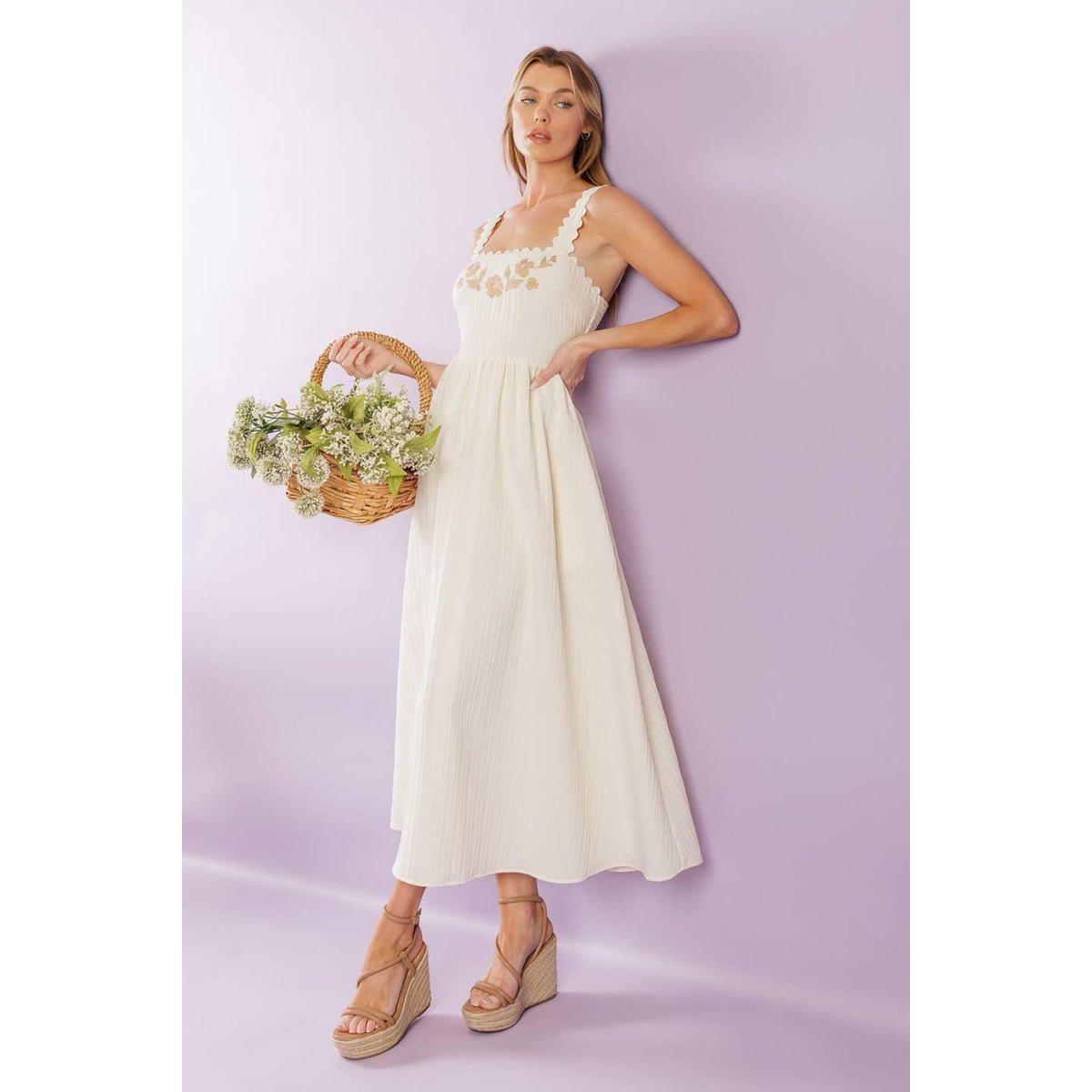a woman in a white dress holding a basket of flowers