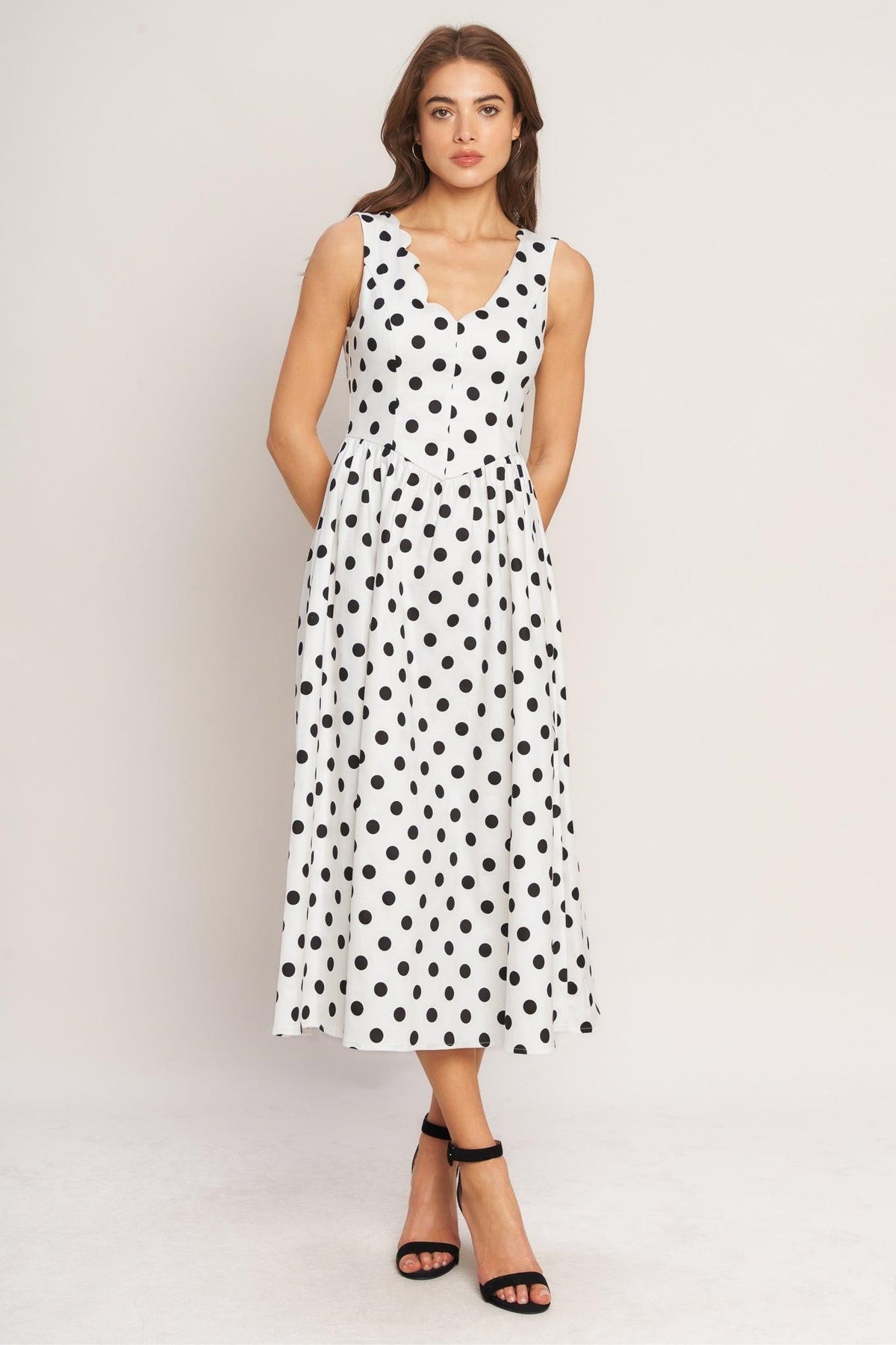 a woman in a white dress with black dots