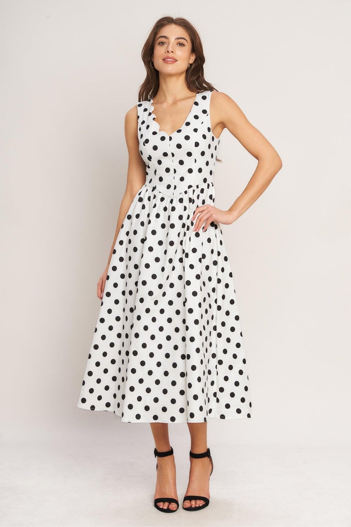 a woman in a white dress with black dots