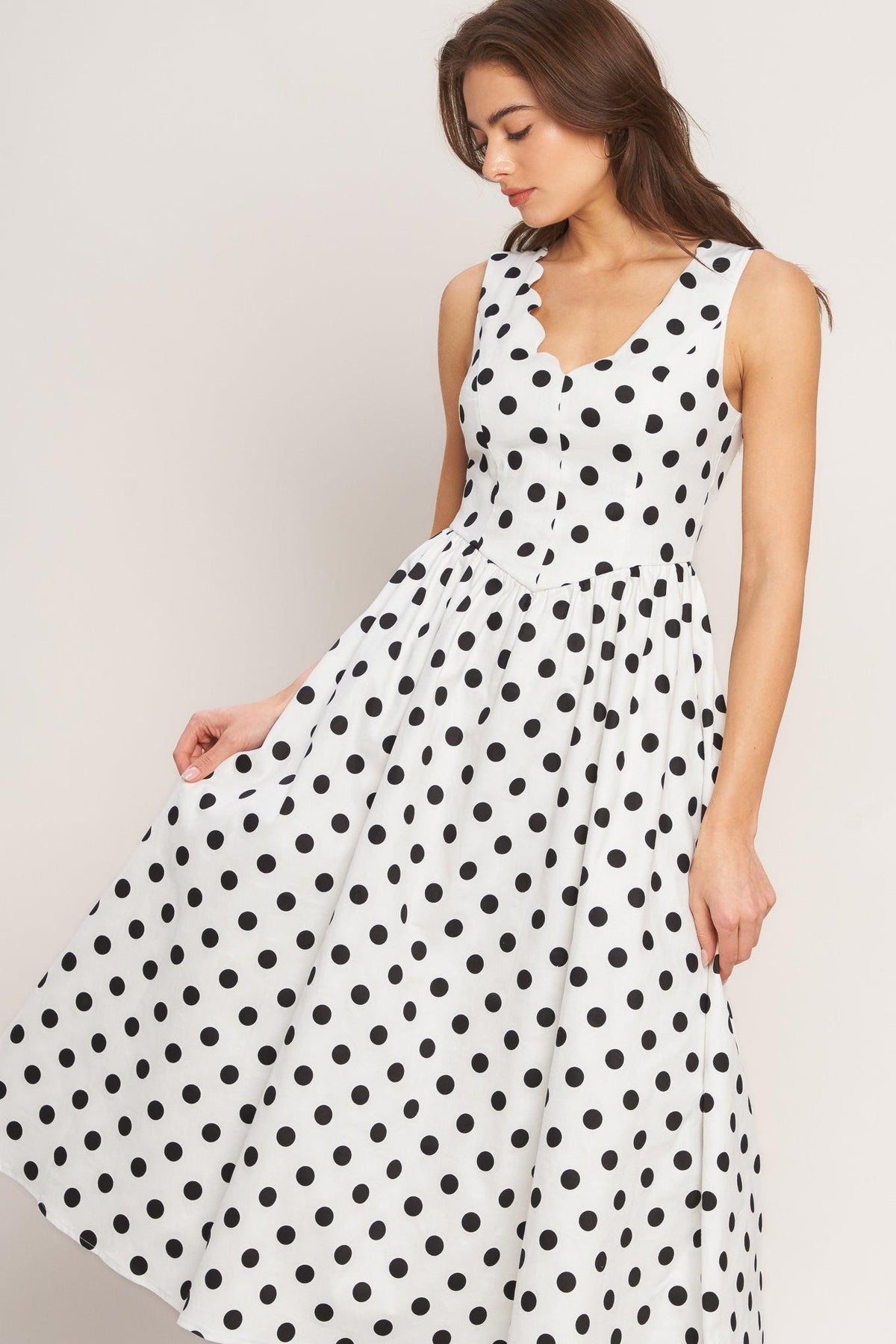 a woman in a white dress with black dots