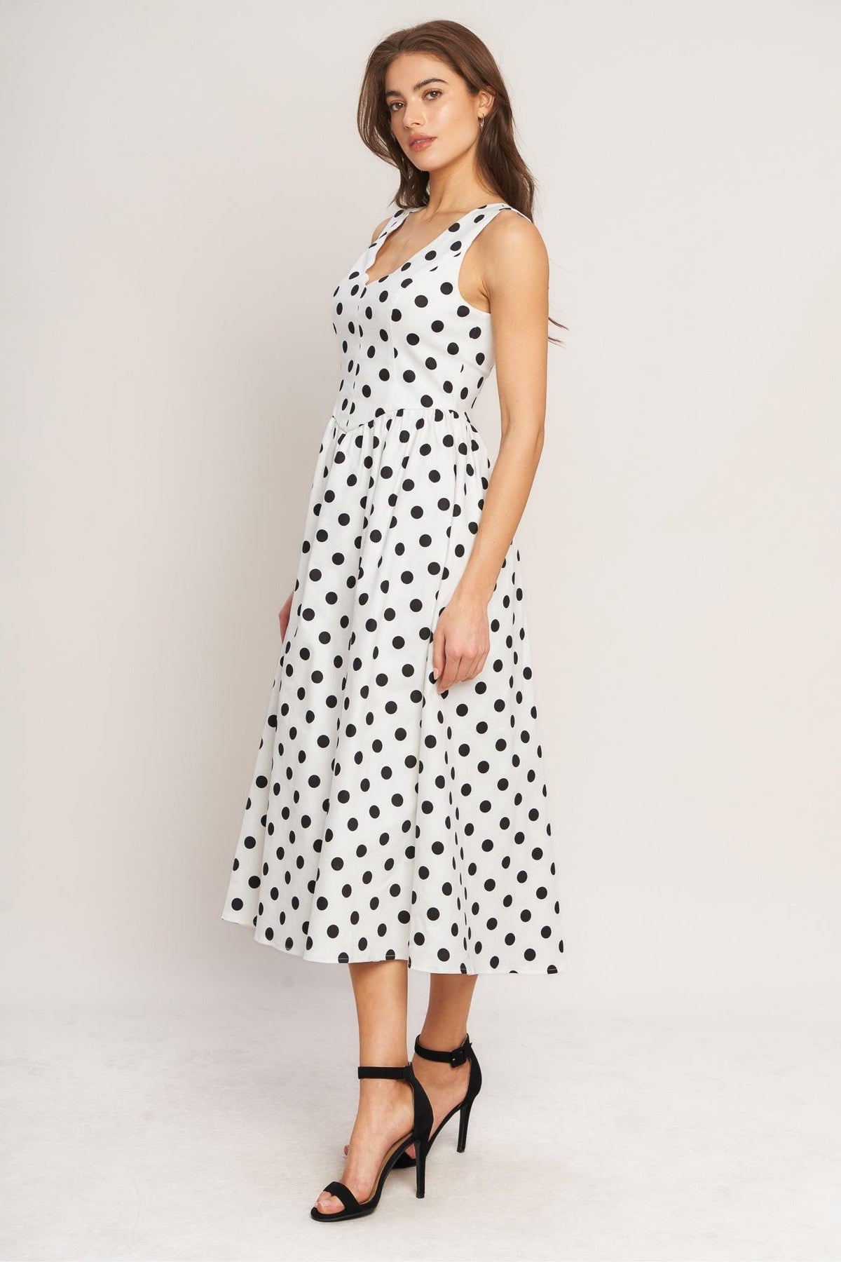 a woman in a white dress with black dots
