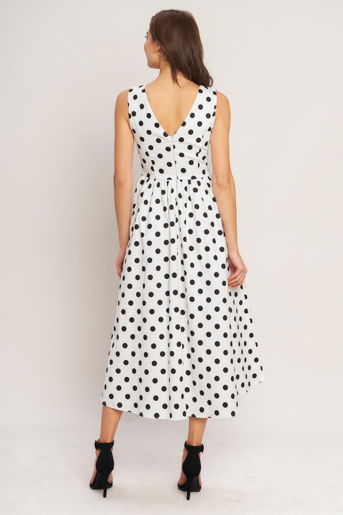 a woman in a white dress with black polka dots