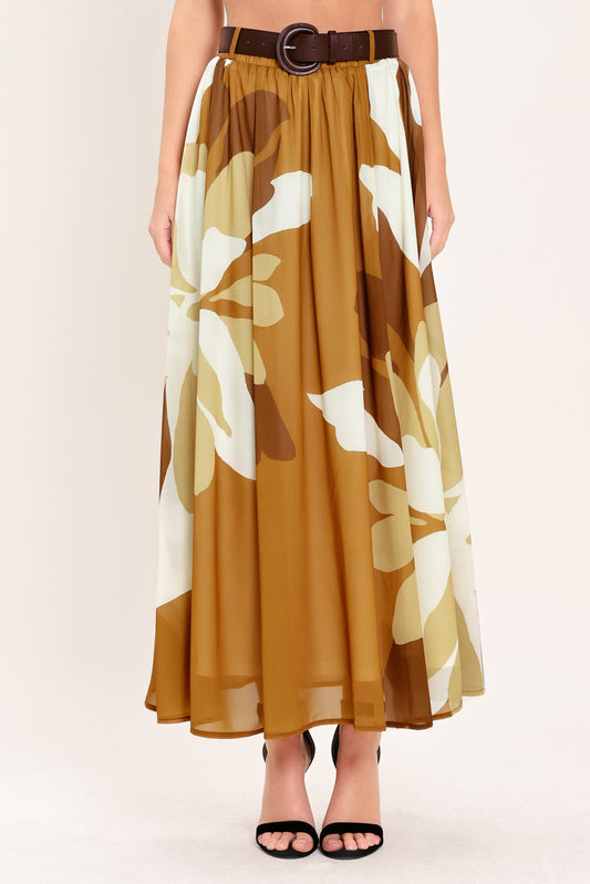 a woman wearing a long brown and white floral dress