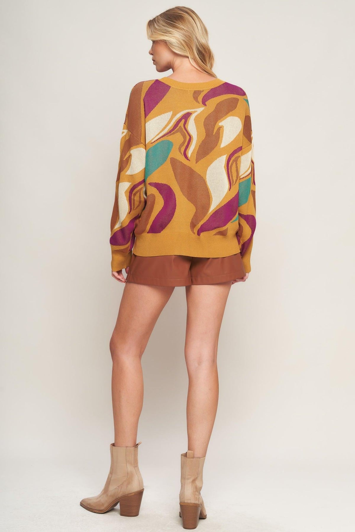 a woman wearing a sweater and shorts