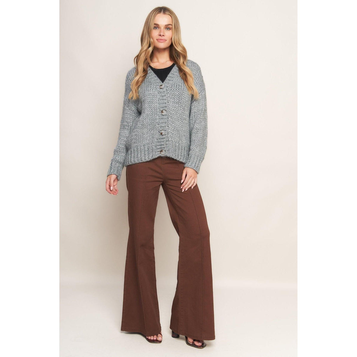 a woman in a sweater and brown pants
