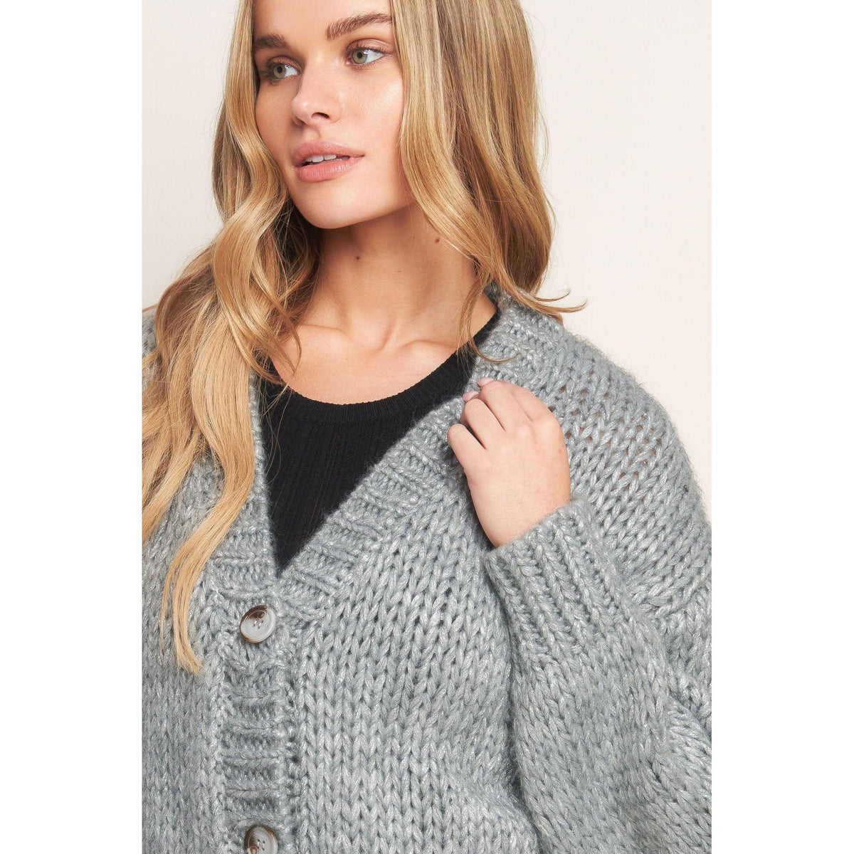 a woman with blonde hair wearing a grey sweater
