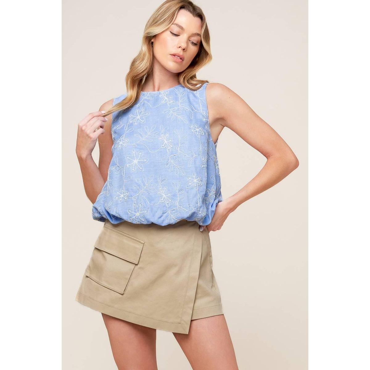 a woman in a blue top and tan skirt
