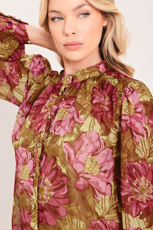 a woman with blonde hair wearing a floral shirt