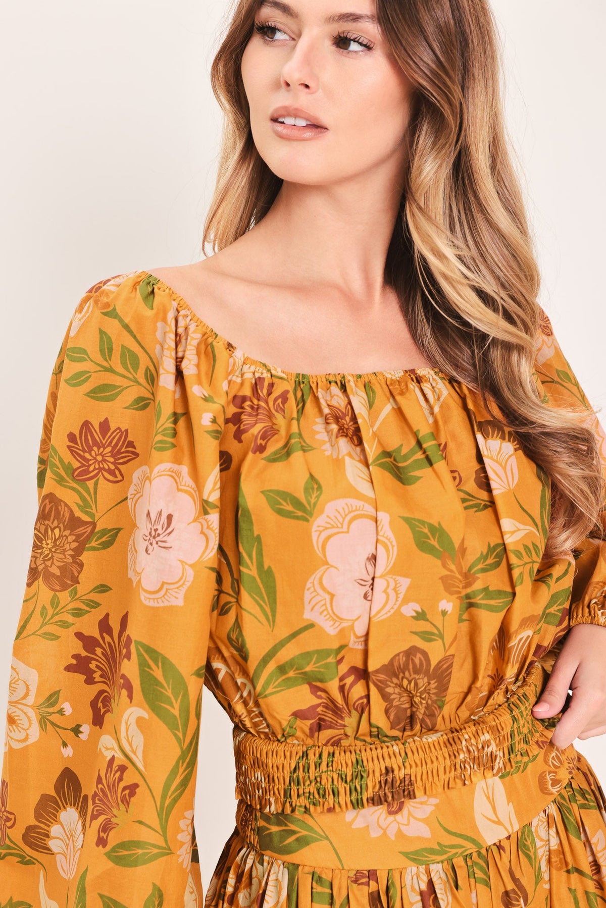 a woman wearing a yellow floral dress