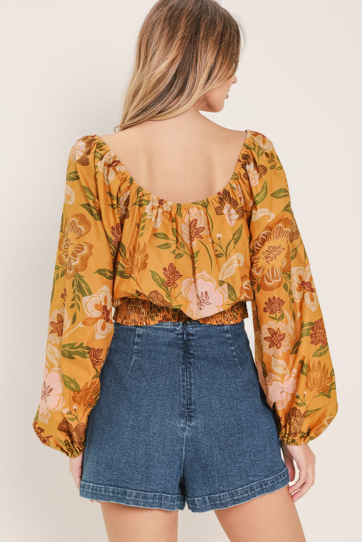 a woman wearing a yellow floral top