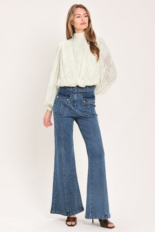 a woman in a white blouse and blue jeans