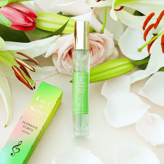a bottle of perfume next to flowers