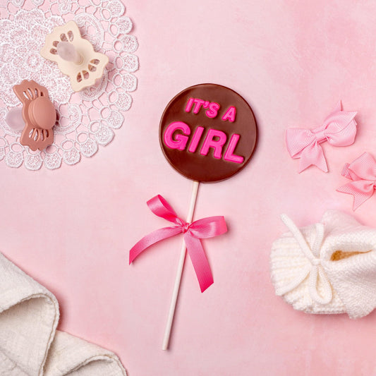 a lollipop with pink letters and bows and a baby booties