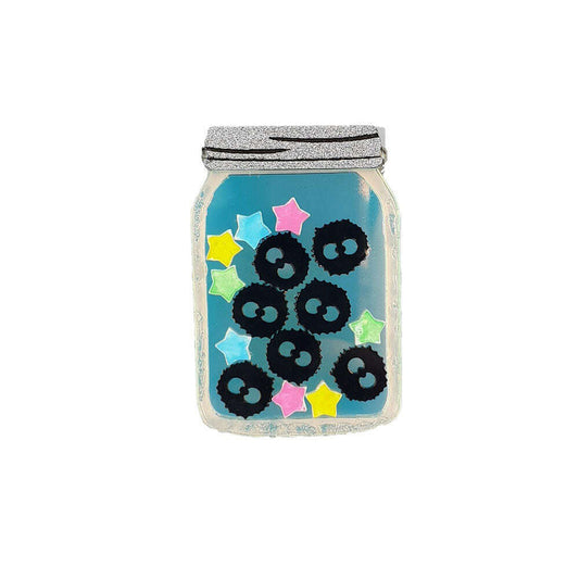 a glass jar with blue liquid and black balls