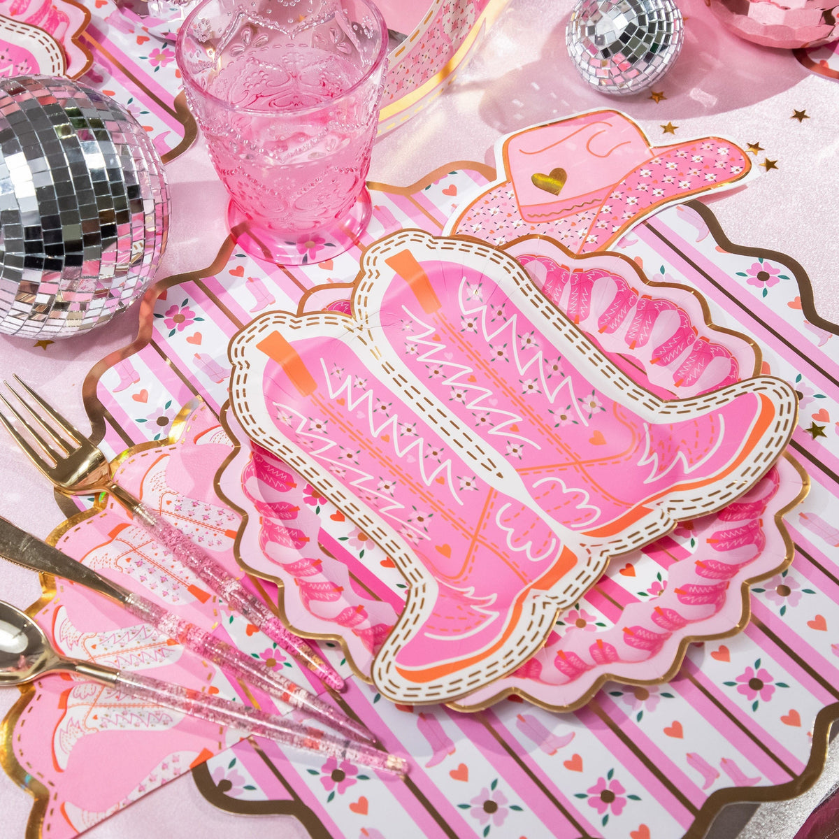 a pink table setting with silverware and utensils