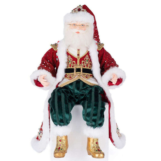 a santa claus doll sitting on a white surface