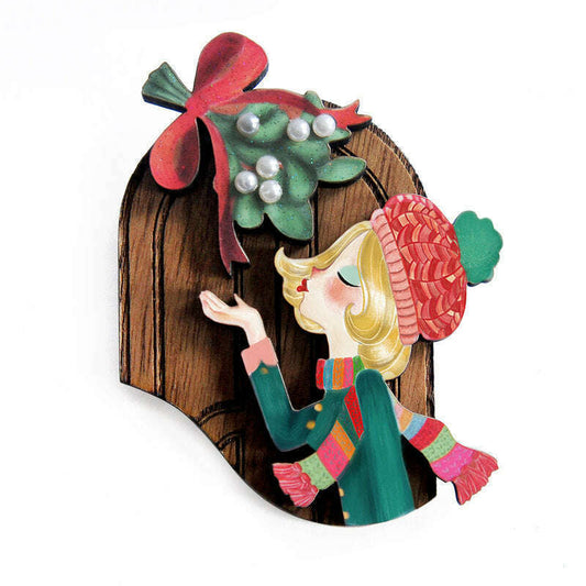 a wooden christmas ornament with a cartoon of a woman holding a holly