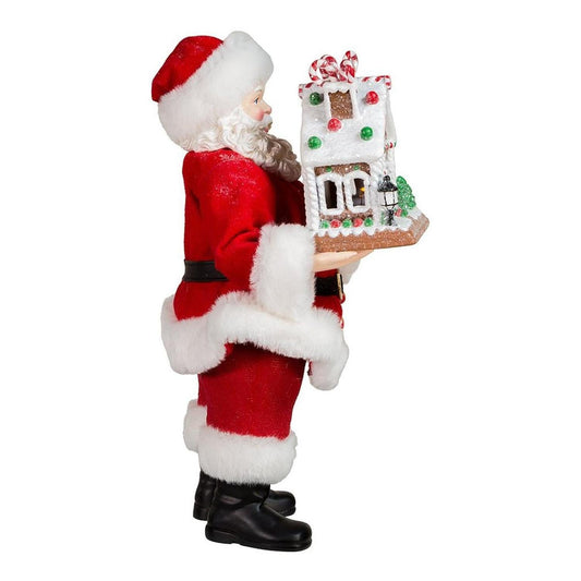 a person in a garment holding a gingerbread house