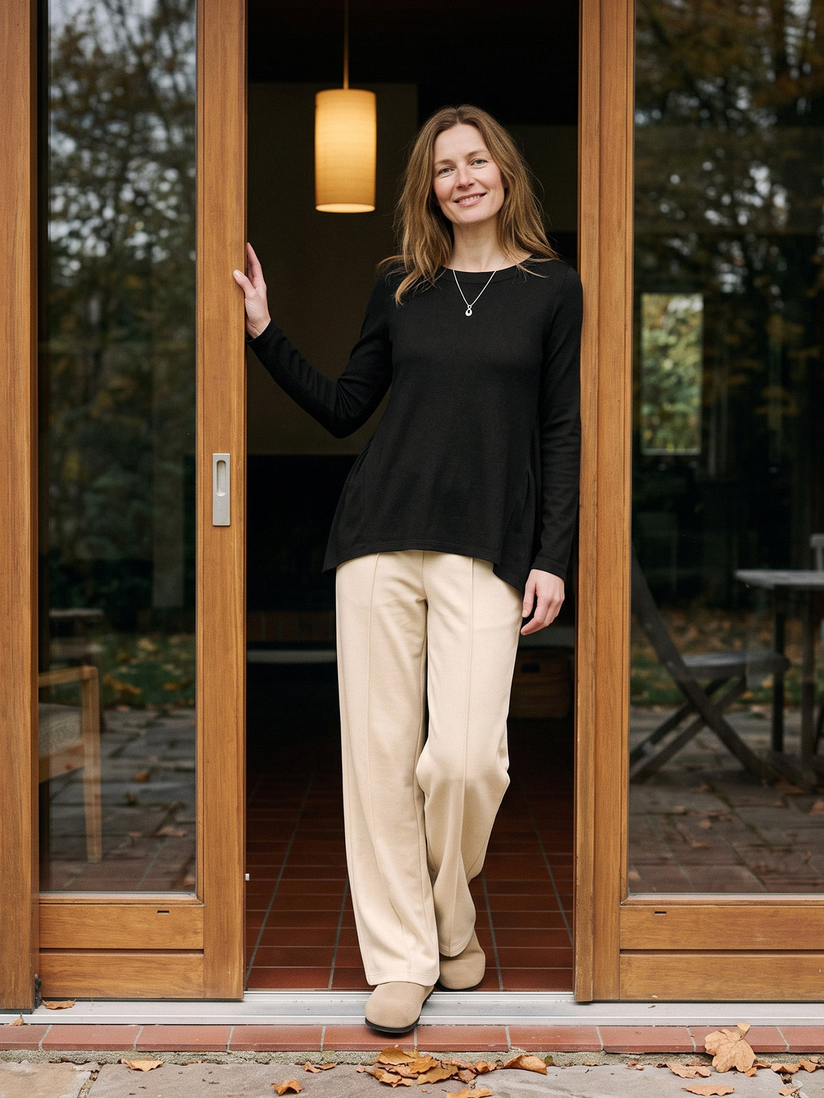 a woman standing in front of a glass door