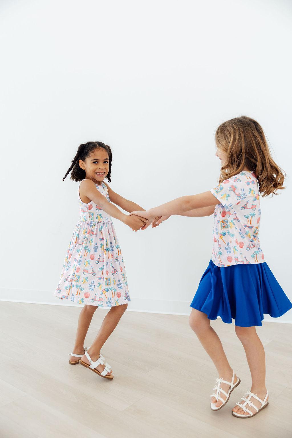 two girls holding hands and dancing