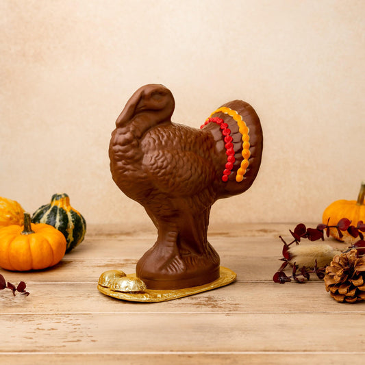 a chocolate turkey with pumpkins and pine cones
