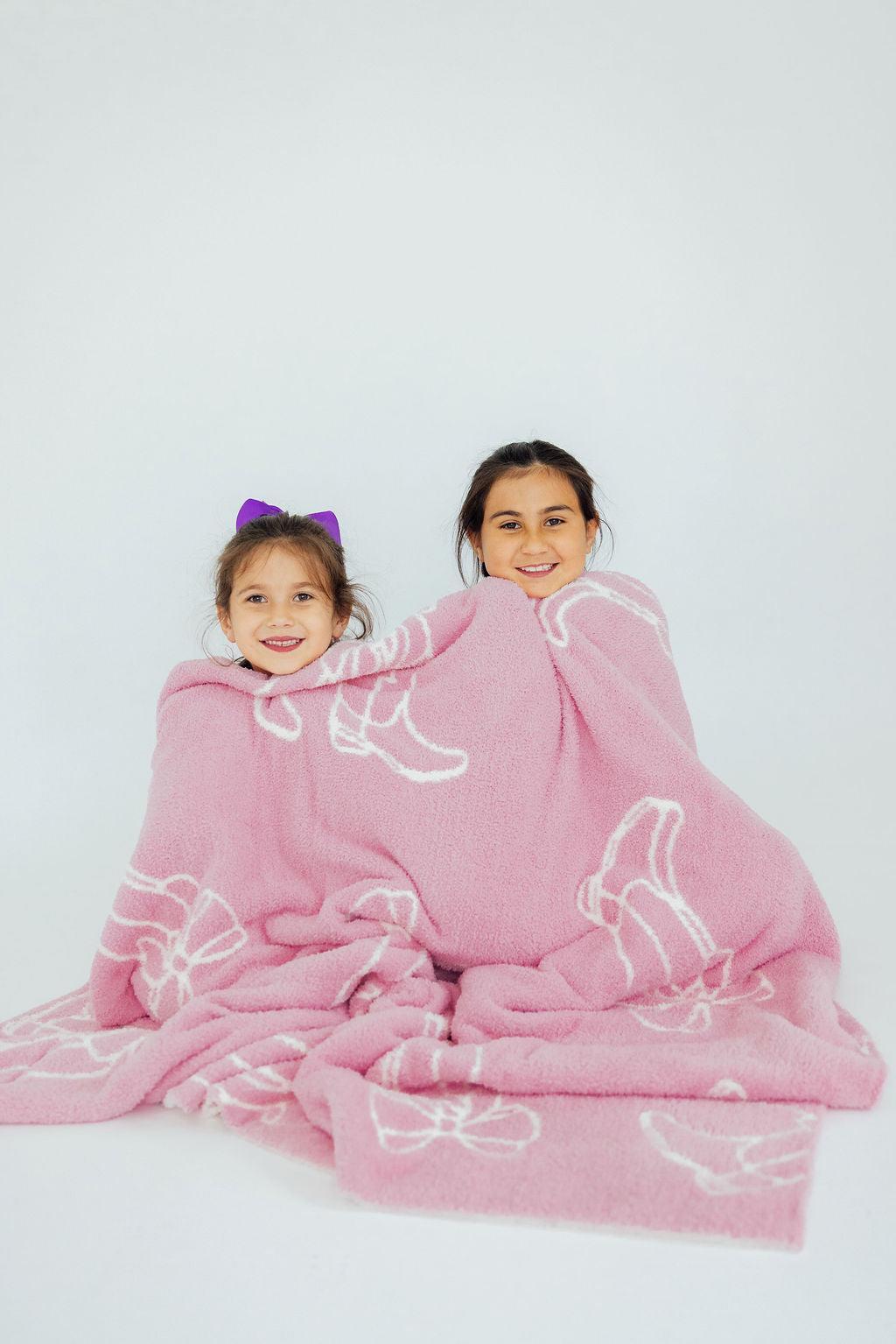 two girls wrapped in a blanket