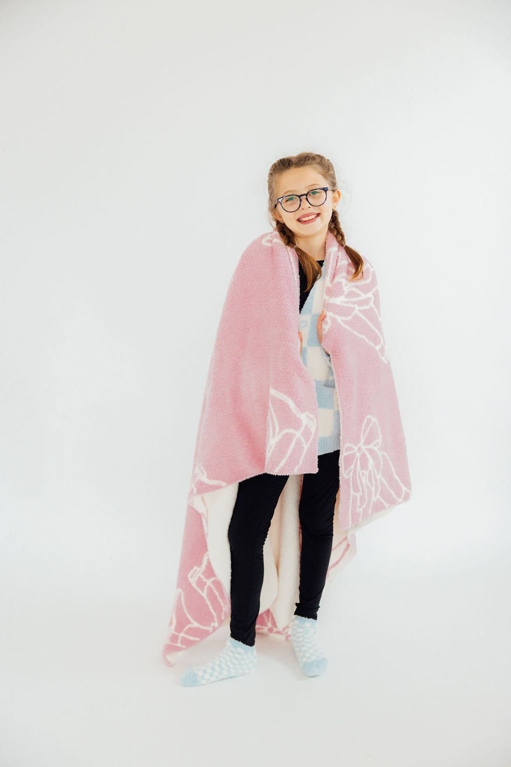a girl wearing glasses and a pink blanket
