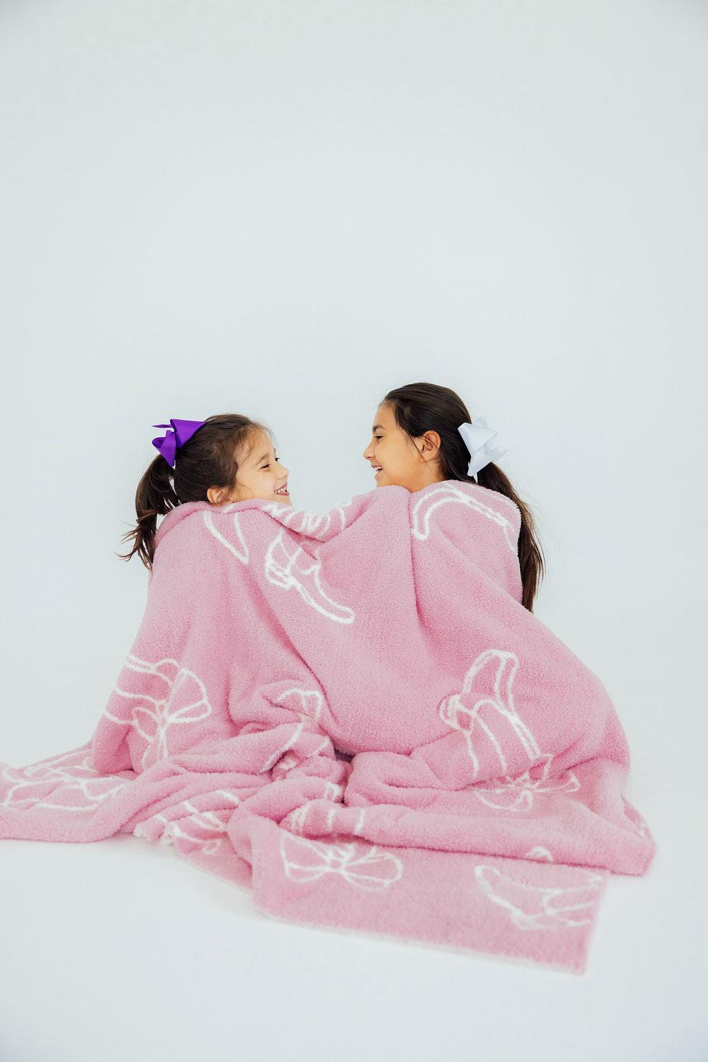 two girls sitting in a blanket