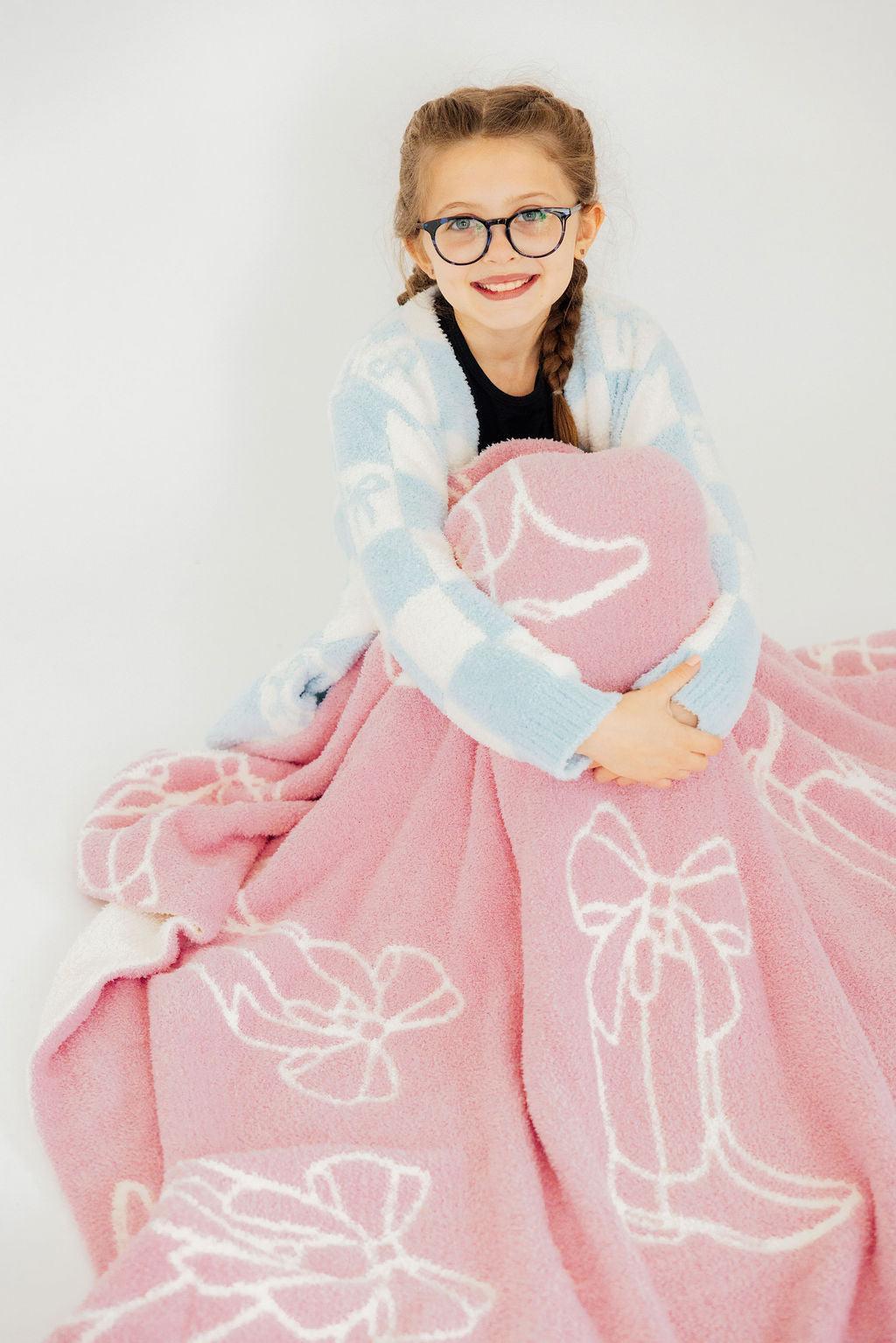 a girl wrapped in a pink blanket