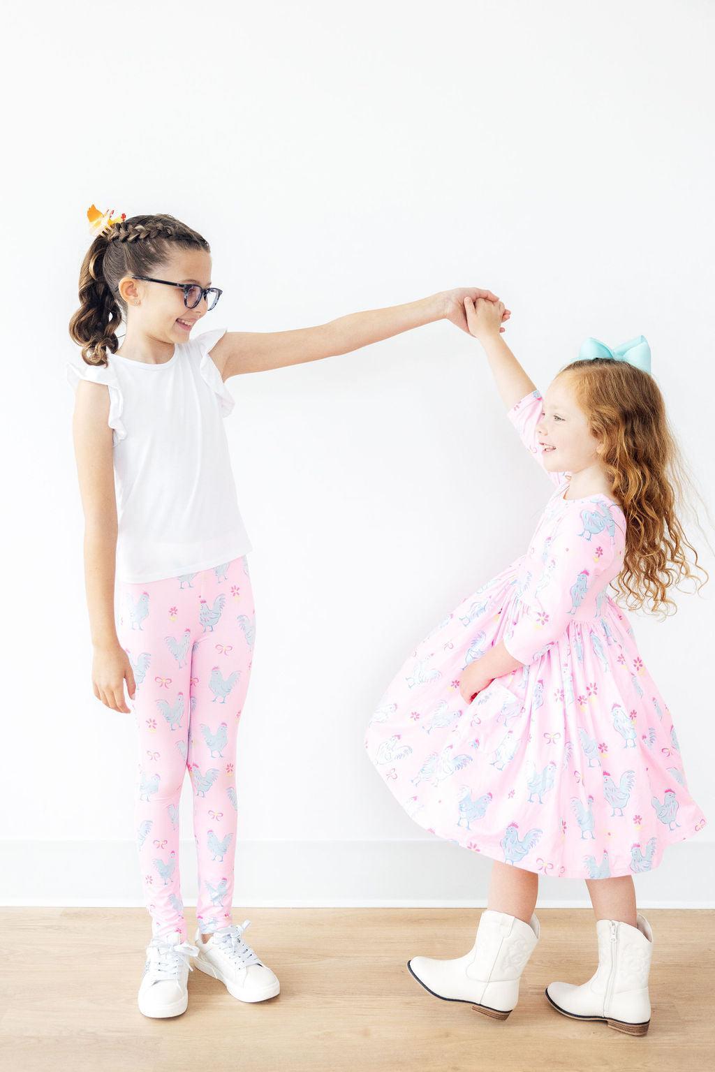 two girls holding hands and dancing