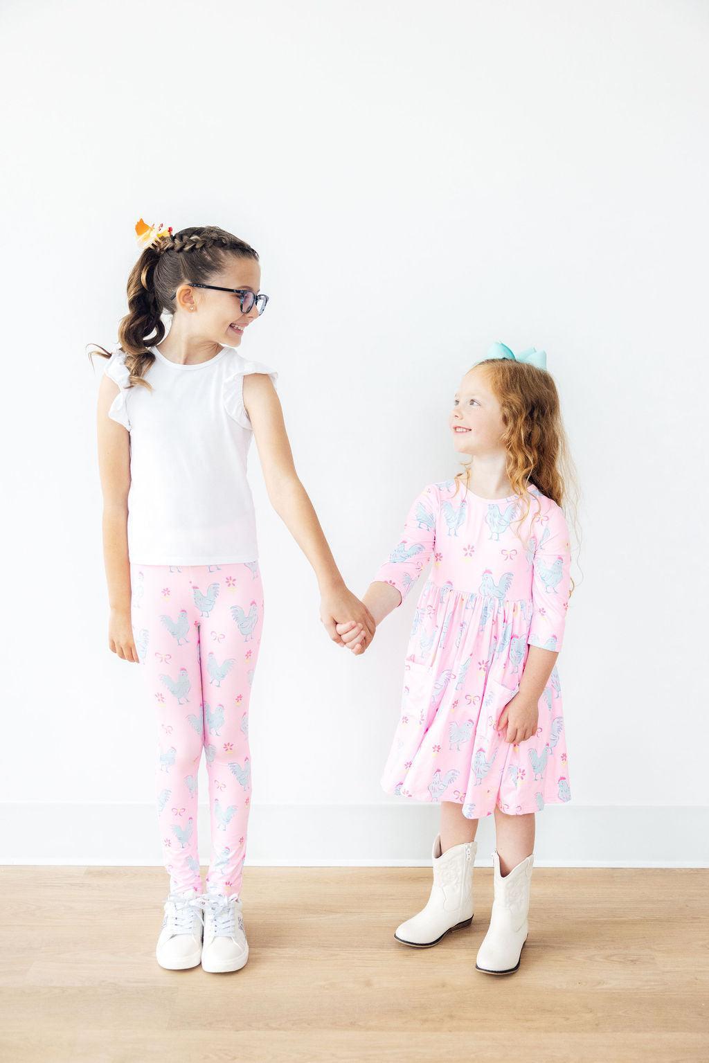 two girls holding hands and smiling