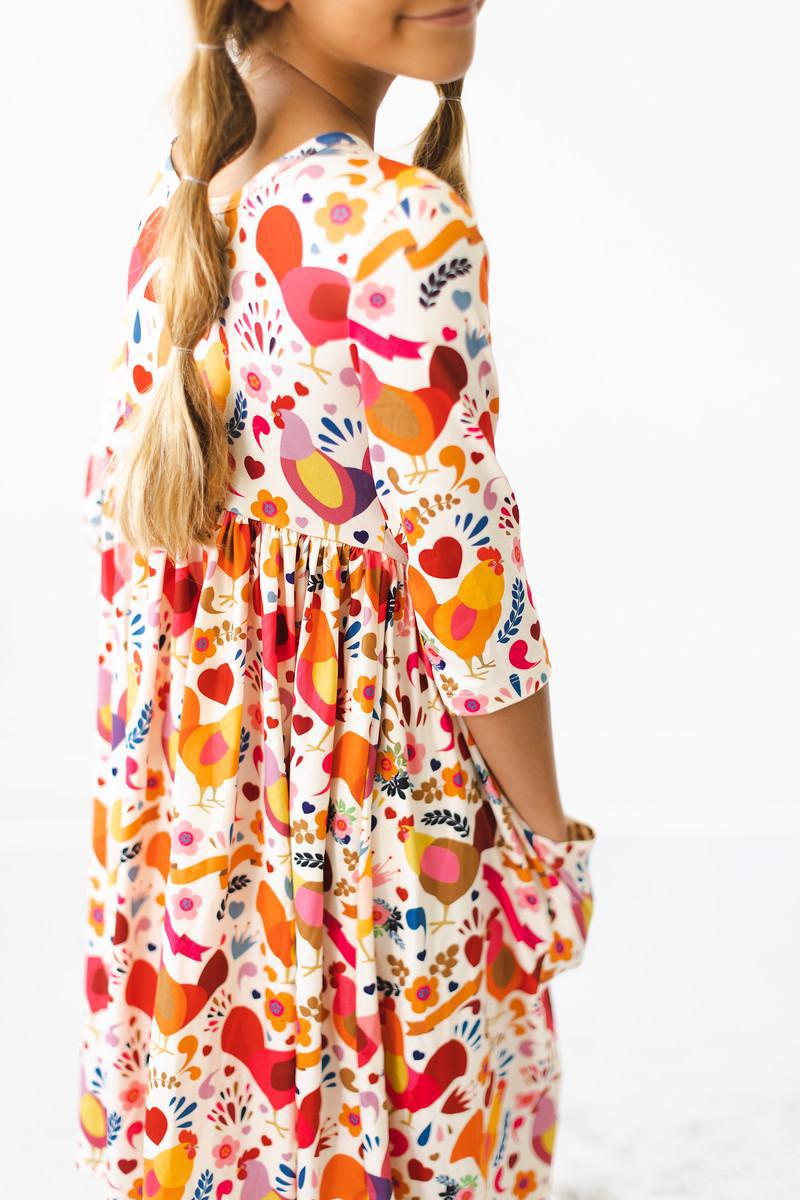 a woman wearing a dress with birds on it