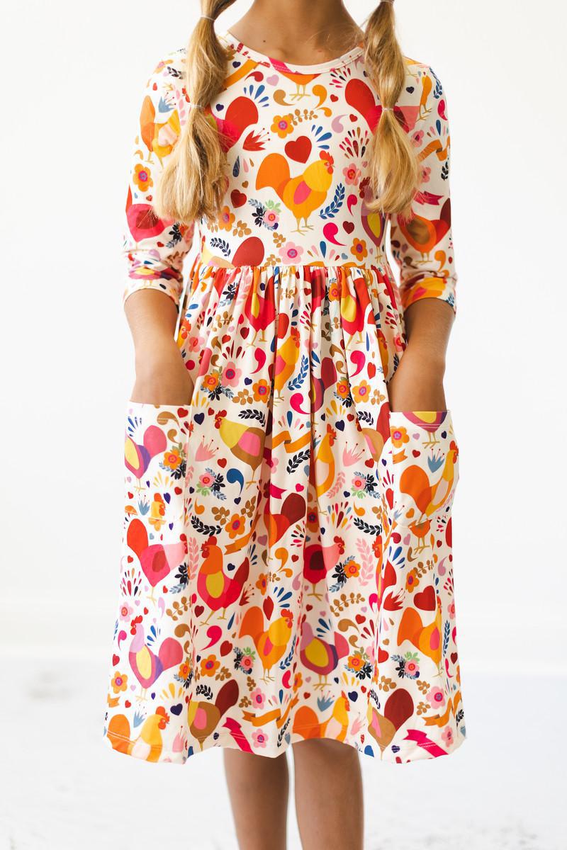 a girl wearing a dress with birds on it