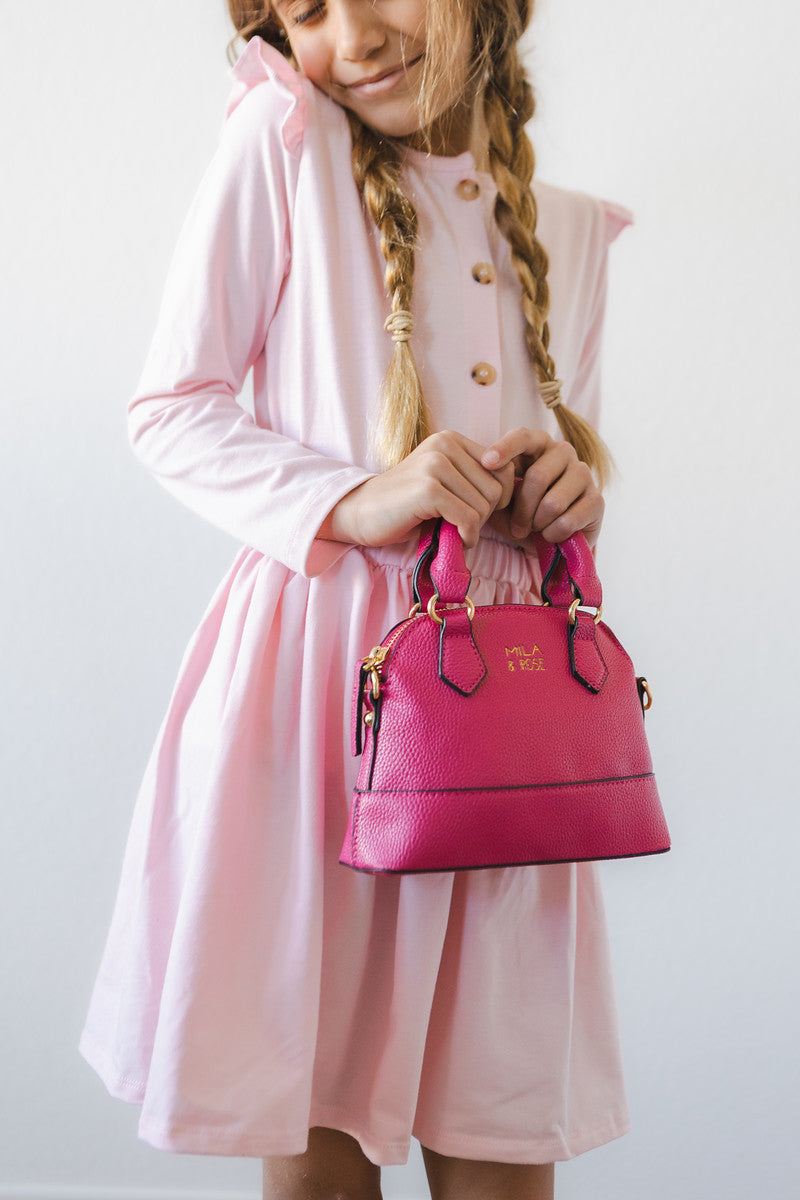 a girl holding a pink purse